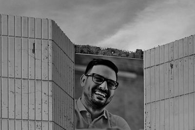 Portrait of smiling young man against sky