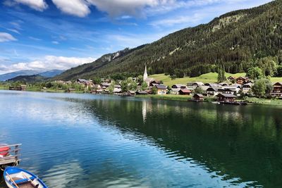 Scenic view of lake by buildings against sky