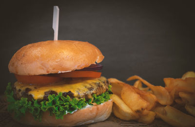 Close-up of burger on table against black background