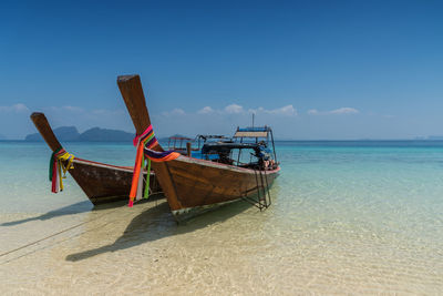 Ship moored on beach against sky