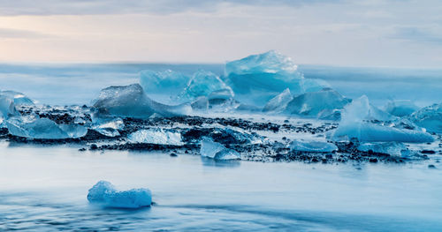Icebergs in sea against sky