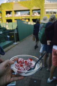 Midsection of people holding ice cream in bowl