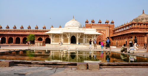 Tourist at tomb of sheikh salim chishti in jama masjid against sky