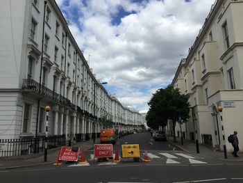 View of city street against cloudy sky