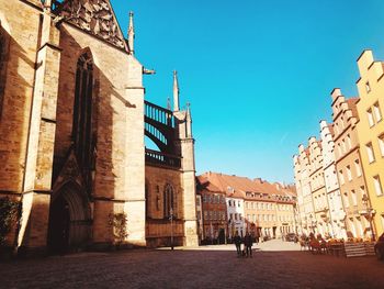 People walking on old building in city