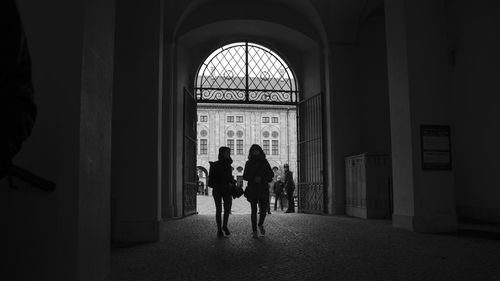 Rear view of silhouette people walking in building