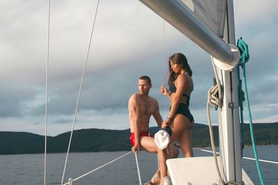 Young couple on yacht against sky