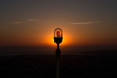 Silhouette of road sign against sky during sunset