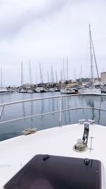 Sailboats moored in sea against sky