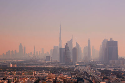 Silhouette burj khalifa in city during foggy weather