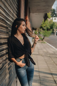 Thoughtful woman standing by closed shutter