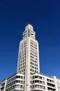 Low angle view of skyscraper against clear blue sky