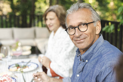 Portrait of smiling retired senior man sitting at dining table