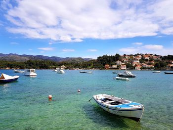 Boats moored in sea against sky