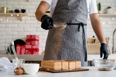 Midsection of man preparing food in kitchen