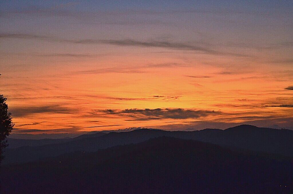 sunset, scenics, tranquil scene, tranquility, beauty in nature, silhouette, mountain, orange color, sky, idyllic, nature, mountain range, landscape, cloud - sky, majestic, non-urban scene, dusk, dramatic sky, outdoors, cloud