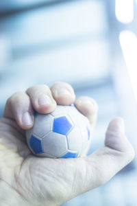 Close-up of hand holding ball at home