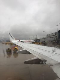 Airplane on airport runway against sky