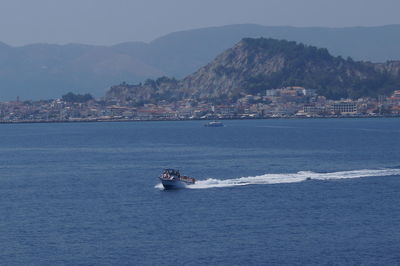 Boat sailing on sea against clear sky