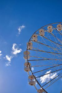 Low angle view of ferris wheel against blue sky