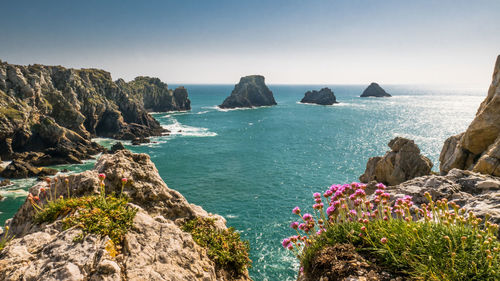 Scenic view of rocks in sea against sky