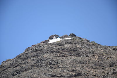 Low angle view of rock formations against clear blue sky