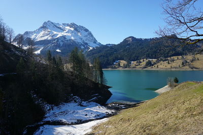 Scenic view of lake and snowcapped mountains against sky