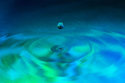 Close-up of water drop against blue sky