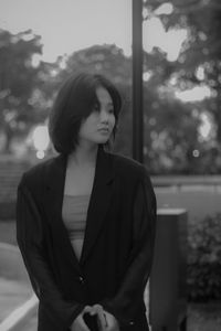 Young woman looking at camera while standing outdoors