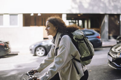 Portrait of young woman sitting on street