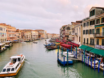 Boats moored in canal in city