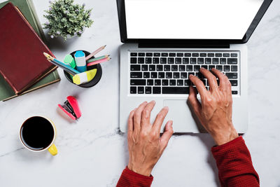 High angle view of woman using laptop on table