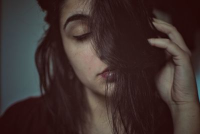 Close-up of young woman with hand in hair