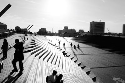 People photographing on city against sky