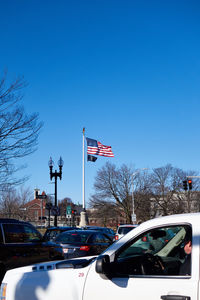 Cars on city street against clear sky