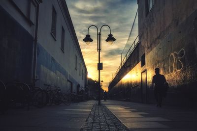Street in city against sky during sunset