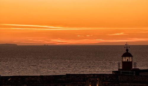 Scenic view of sea against orange sky