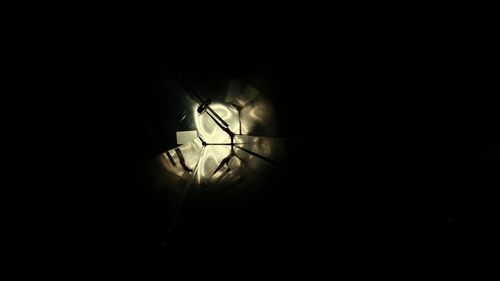 Low angle view of illuminated light bulb in the dark