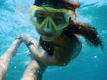 Portrait of woman swimming with man in sea