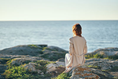 Rear view of woman looking at sea against sky