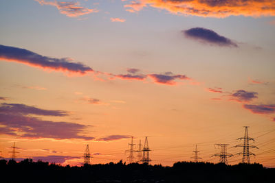 Low angle view of silhouette electricity pylon against romantic sky
