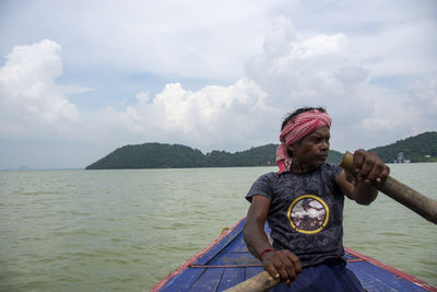 A poor tribal man pulling boat by his hand with paddle