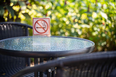 Close-up of no smoking sign on glass table at sidewalk cafe