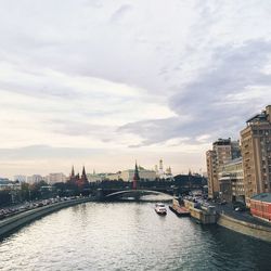 City at waterfront against cloudy sky