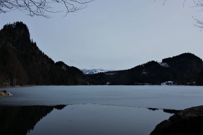 Scenic view of river by mountains against sky