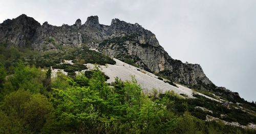 Low angle view of rocks on mountain against sky