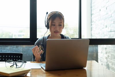 Young woman using laptop at table