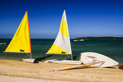 Sailboat on beach against blue sky