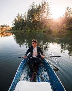 Full length of man sitting on rowboat in lake