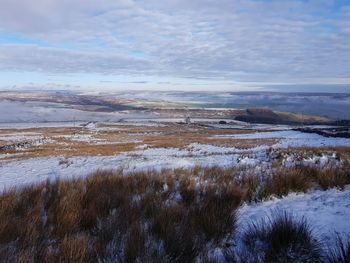 Scenic view of snow covered land against sky